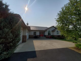 Weathered Interlock Shake aluminum roof on a white ranch-style home with a metal roof and trees, Sherwood Park, Alberta