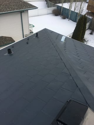 Deep Charcoal Interlock Slate aluminum roof on a single-storey home with a metal roof in a snowy rural, Fort Saskatchewan, Alberta