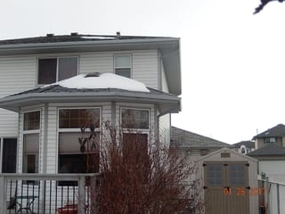 Deep Charcoal Interlock Slate aluminum roof on a white two-storey home with dormers in a snowy rural, Fort Saskatchewan, Alberta