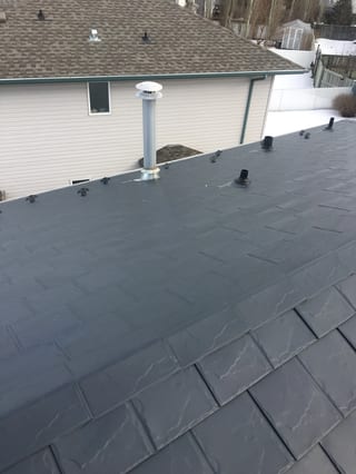 Deep Charcoal Interlock Slate aluminum roof on a single-storey modern home in a snow-covered rural setting, Fort Saskatchewan, Alberta