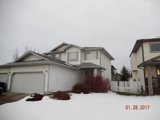 Deep Charcoal Interlock Slate aluminum roof on a white modern home with snow in a rural setting, Fort Saskatchewan, Alberta