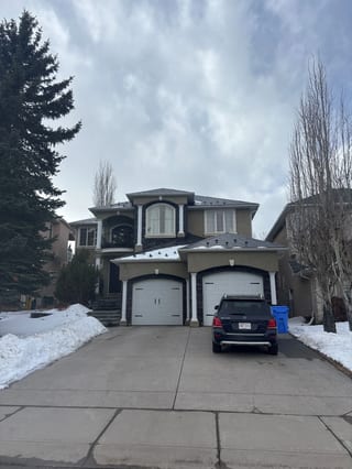 Black Interlock Slate aluminum roof on a brown two-storey home with dormers in a snow-covered, Calgary, Alberta
