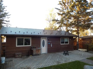 Tudor Brown Interlock Slate aluminum roof on a brown Tudor home with dormers among tall pines, Pelican Narrows, Alberta