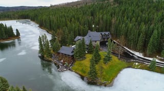 Black Interlock Shake aluminum roof on a metal roof on a chalet-style home among tall trees in the, Bragg Creek, Alberta