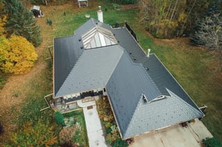 Black Interlock Slate aluminum roof on a black home with a metal roof in a forested rural setting, Spruce Grove, Alberta