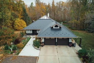 Black Interlock Slate aluminum roof on a modern home with dark roof in a forested rural area, Spruce Grove, Alberta
