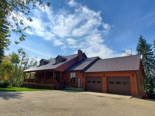 Colonial Brown Interlock Shake aluminum roof on a brown two-storey home with a garage in a rural setting, Red Deer County, Alberta