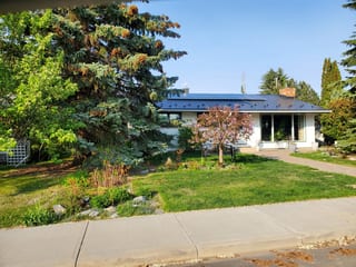 Black Interlock Slate aluminum roof on a white ranch home with a slate metal roof in a suburban, Edmonton, Alberta