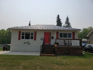 Black Interlock Slate aluminum roof on a white single-storey ranch home with dormers among tall, Fort Saskatchewan, Alberta