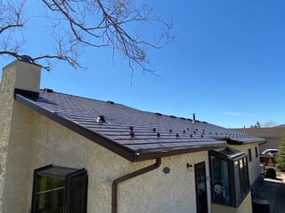 Colonial Brown Interlock Slate aluminum roof on a brown two-storey home with dormers in a rural suburban, Oyen, Alberta