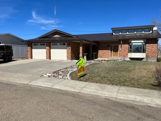 Colonial Brown Interlock Slate aluminum roof on a brown single-storey home with dormers in a rural setting, Oyen, Alberta