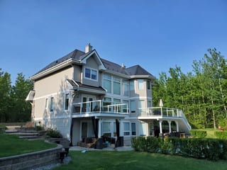 Black Interlock Cedar Shingle aluminum roof on a two-storey home with a black metal roof in a forested area, Sherwood Park, Alberta