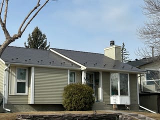 Tile Red Interlock Slate aluminum roof on a beige ranch-style home with a metal roof in a suburban, Calgary, Alberta
