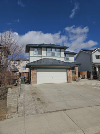 Deep Charcoal Interlock Slate aluminum roof on a two-storey home with stone accents and a metal roof in a, Chestermere, Alberta