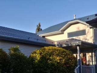 Royal Blue Interlock Slate aluminum roof on a Royal Blue Interlock Slate metal roof on a white home in, Devon, Alberta