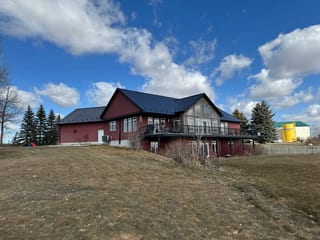 Black Interlock Slate aluminum roof on a modern red home with a black metal roof on an acreage, Gem, Alberta