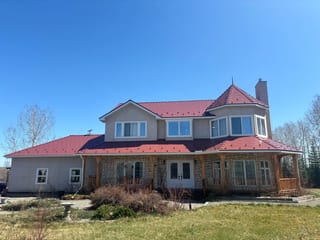 Tile Red Interlock Slate aluminum roof on a grey two-storey home with dormers on an acreage, Foothills County, Alberta