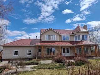 Tile Red Interlock Slate aluminum roof on a red metal roof on a two-storey ranch style home in the, Foothills County, Alberta