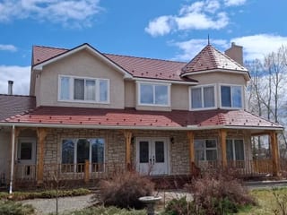 Tile Red Interlock Slate aluminum roof on a two-storey modern home with red metal roof among rural, Foothills County, Alberta