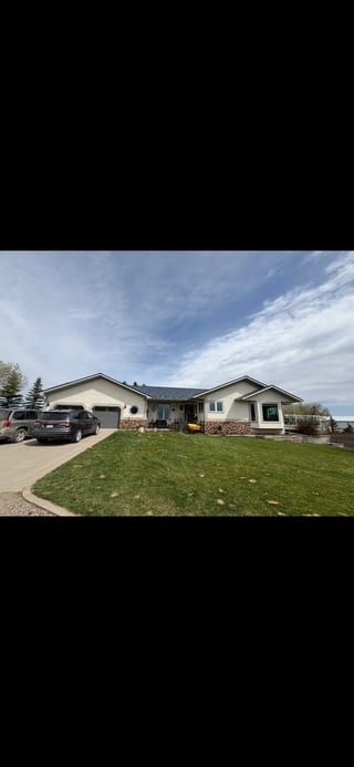 Deep Charcoal Interlock Slate aluminum roof on a white ranch-style home with a metal roof in a rural, Red Deer County, Alberta