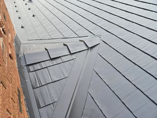 Tudor Brown Interlock Cedar Shingle aluminum roof on a brown two-storey Tudor home with dormers in the mountains, Rocky Mountain House, Alberta