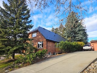 Deep Charcoal Interlock Slate aluminum roof on a brick home with a metal roof and a driveway in a suburban, Calgary, Alberta
