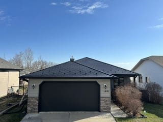 Deep Charcoal Interlock Cedar Shingle aluminum roof on a white single-storey home with a metal roof in a rural area, Drayton Valley, Alberta