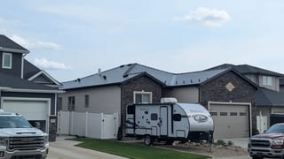 Black Interlock Slate aluminum roof on a black house with a metal roof in a rural area, Medicine Hat, Alberta
