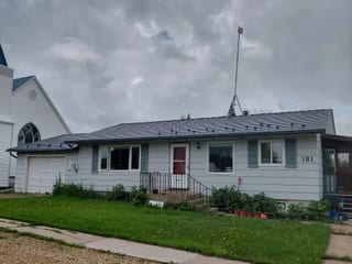 Deep Charcoal Interlock Slate aluminum roof on a Deep Charcoal metal roof on a white ranch style home in a, Edberg, Alberta