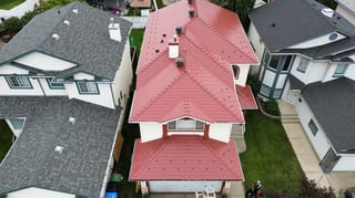 Tile Red Interlock Slate aluminum roof on a two-storey home with a red metal roof in a suburban, Calgary, Alberta