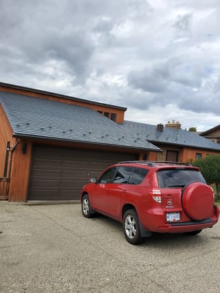 Slate Blue Interlock Slate aluminum roof on a red metal roof on a brown house in a mountain setting, Vernon, British Columbia