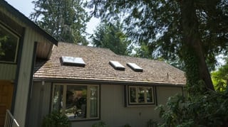 Before: a mossy wood shake roof on the home, Sechelt, British Columbia, ahead of a Deep Charcoal Interlock Slate aluminum roof