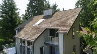 Before: a mossy wood shake roof on the home, Sechelt, British Columbia, ahead of a Deep Charcoal Interlock Slate aluminum roof