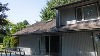 Before: a mossy wood shake roof on the home, Sechelt, British Columbia, ahead of a Deep Charcoal Interlock Slate aluminum roof