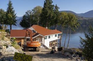 Copper Penny Interlock Slate aluminum roof being installed on a white two-storey home with dormers on a waterfront, Sechelt, British Columbia