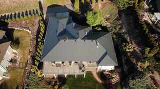 Deep Charcoal Interlock Slate aluminum roof on a single-storey home with a gable roof in a rural mountain, West Kelowna, British Columbia