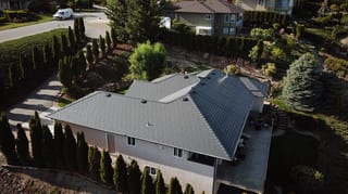 Deep Charcoal Interlock Slate aluminum roof on a beige single-family home with dormers in a mountain, West Kelowna, British Columbia