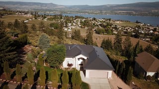 Deep Charcoal Interlock Slate aluminum roof on a white single-storey home with garage and dormer among, West Kelowna, British Columbia