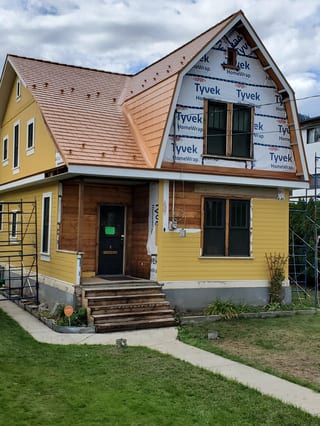 Copper Penny Interlock Cedar Shingle aluminum roof on a yellow single-storey home with a copper penny metal roof, Lumby, British Columbia