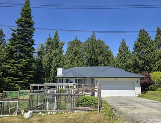 Deep Charcoal Interlock Slate aluminum roof on a white single-storey home with a grey metal roof among, Gibsons, British Columbia