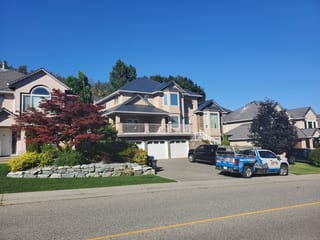 Deep Charcoal Interlock Slate aluminum roof on a tan home with a metal roof on a suburban street in the, Kelowna, British Columbia