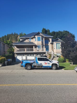 Deep Charcoal Interlock Slate aluminum roof on a modern single-family home with a metal roof in a forested, Kelowna, British Columbia