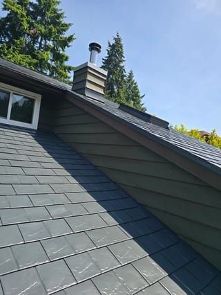 Deep Charcoal Interlock Slate aluminum roof on a two-storey home with dormers in a forested area, Sechelt, British Columbia
