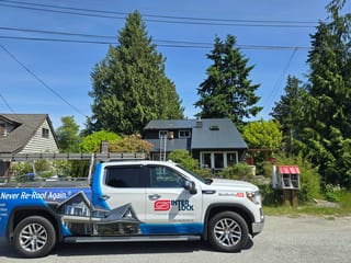 Deep Charcoal Interlock Slate aluminum roof on a gray two-storey home with dormers in a coastal urban, Sechelt, British Columbia