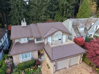 Colonial Brown Interlock Shake aluminum roof on a Colonial-style home with a Colonial Brown roof among tall, North Vancouver, British Columbia