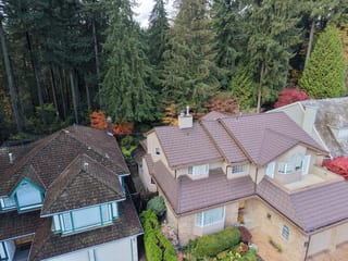 Colonial Brown Interlock Shake aluminum roof on a two-storey Colonial home among tall trees, North Vancouver, British Columbia