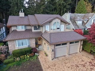 Colonial Brown Interlock Shake aluminum roof on a two-storey colonial home with dormers in a forested urban, North Vancouver, British Columbia