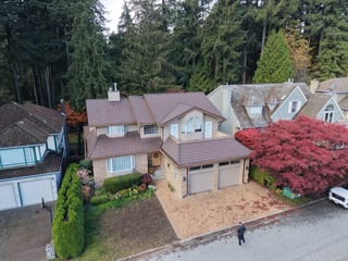 Colonial Brown Interlock Shake aluminum roof on a Colonial-style two-storey home with dormers in a forested, North Vancouver, British Columbia