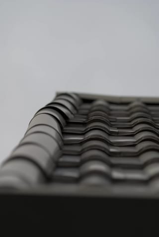 Before: a metal roof with broken tiles on the home, Surrey, British Columbia, ahead of a Black Interlock Slate aluminum roof