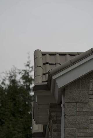 Before: a metal roof with broken tiles on the home, Surrey, British Columbia, ahead of a Black Interlock Slate aluminum roof